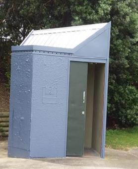 A picture of the previous small grey standalone toilet with minimal accessibility.