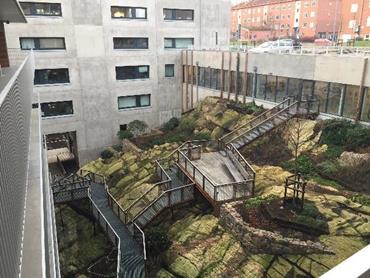 The courtyard of a new built apartment block. The sloping courtyard is equipped with stairs only.