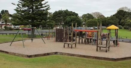 A picture of Keith Hay park prior to refurbishment. Raised wooden connecting platfroms. Bark underlay with raised edge all around the outside (inaccessible to those unable to take a step over the edge or walk/navigate through bark).