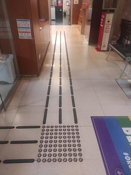 Figure 5: Photo of the building’s entrance and the indoor tactile directional paving leading to the Citizen Information Office counter.