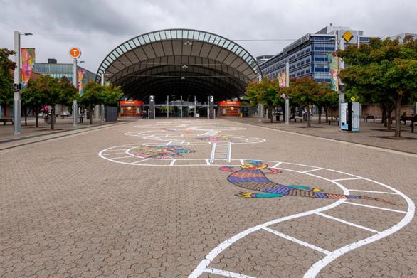 The Snakes and Ladders artwork meandering into the distance through Station Square. In the background is the Sydney Olympic Park train station.